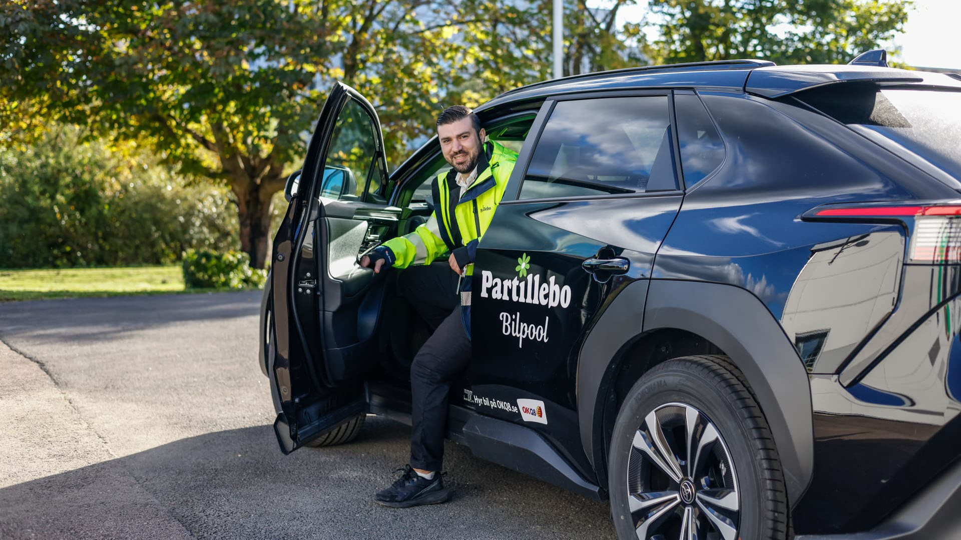 Bilpool Partillebo, person som kliver ut ur bil med Partillebos logotyp