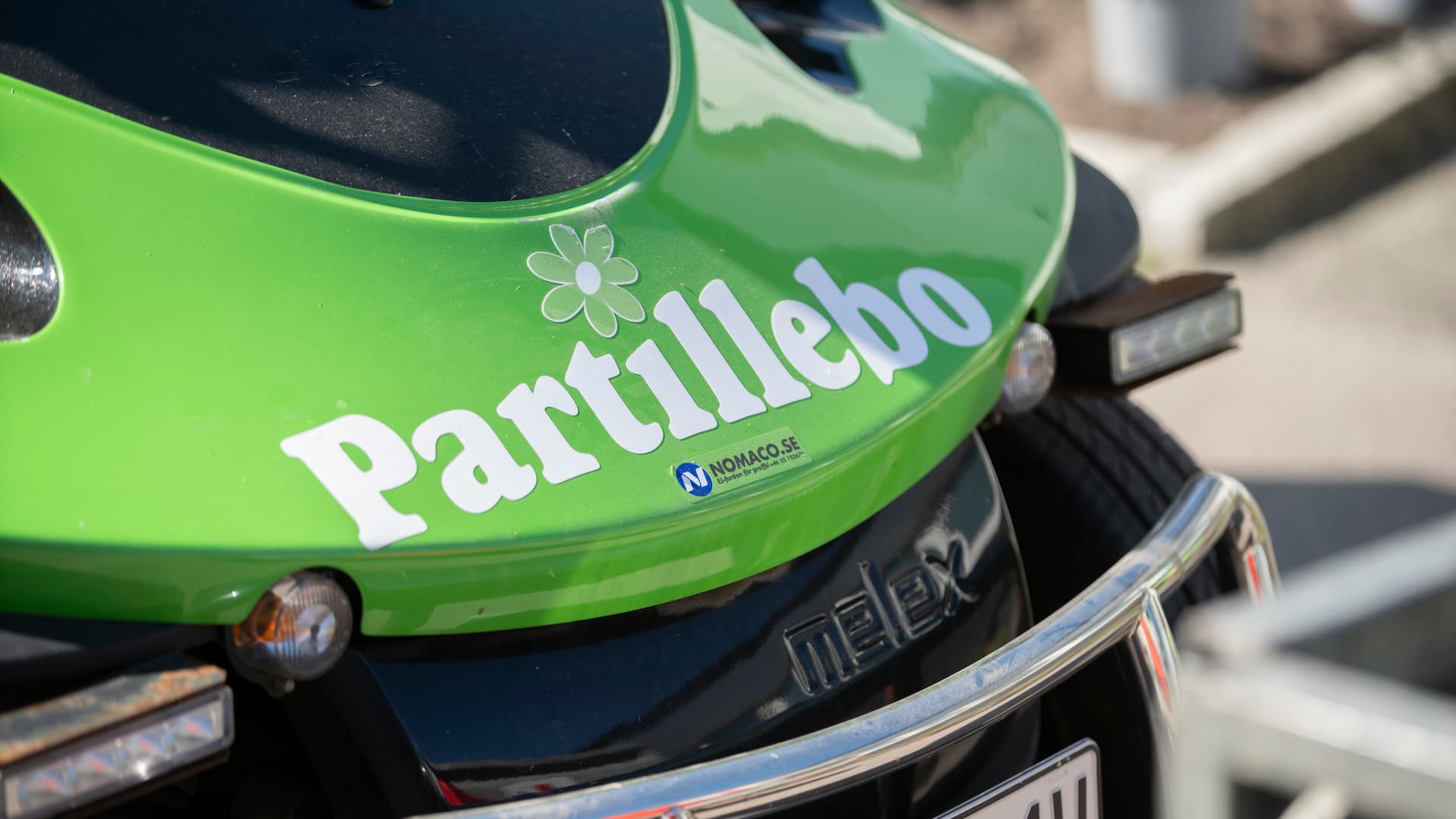 Grönt arbetrsfordon med Partillebos logotyp