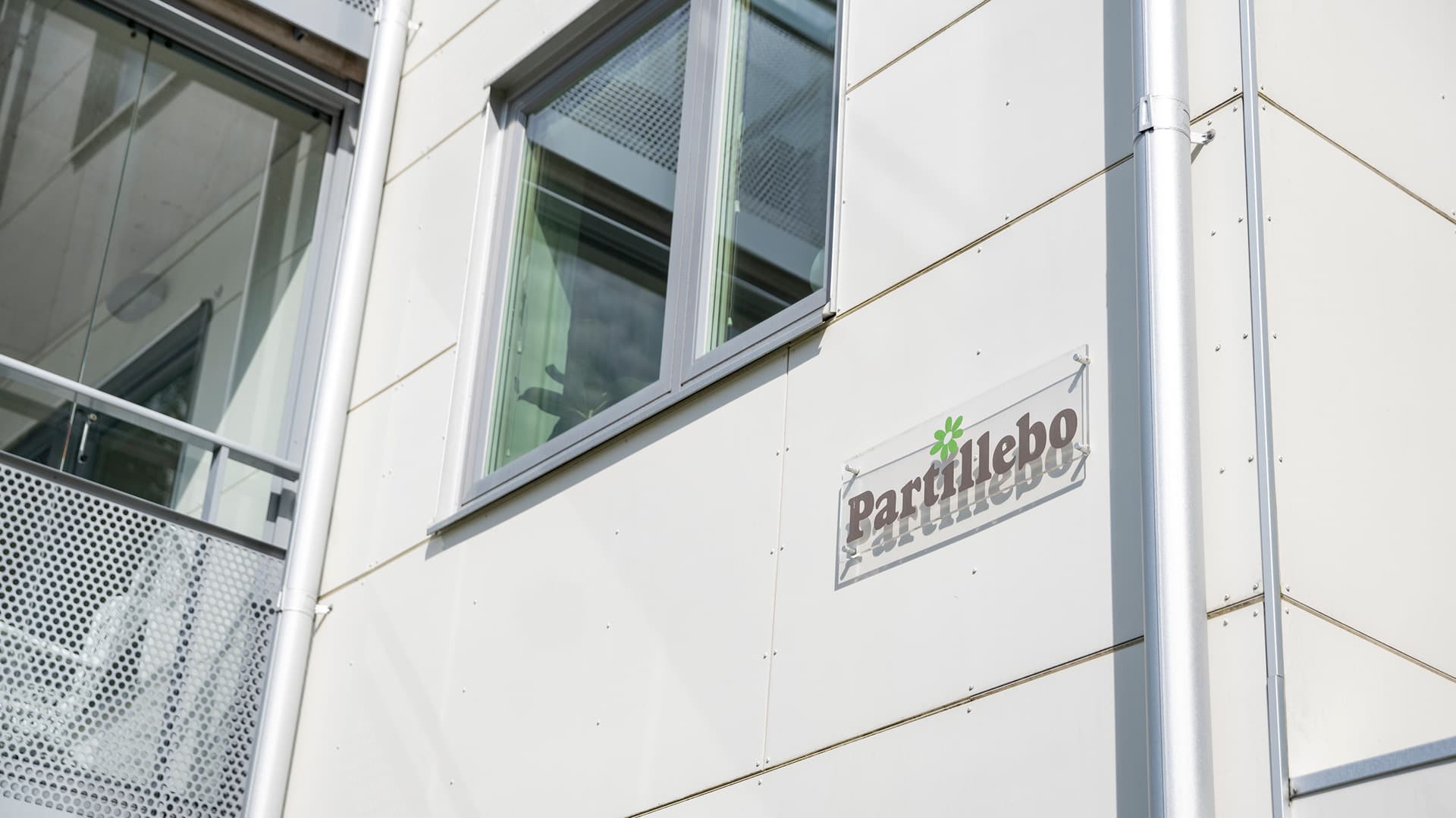 Vit fasad med Partillebos logotyp