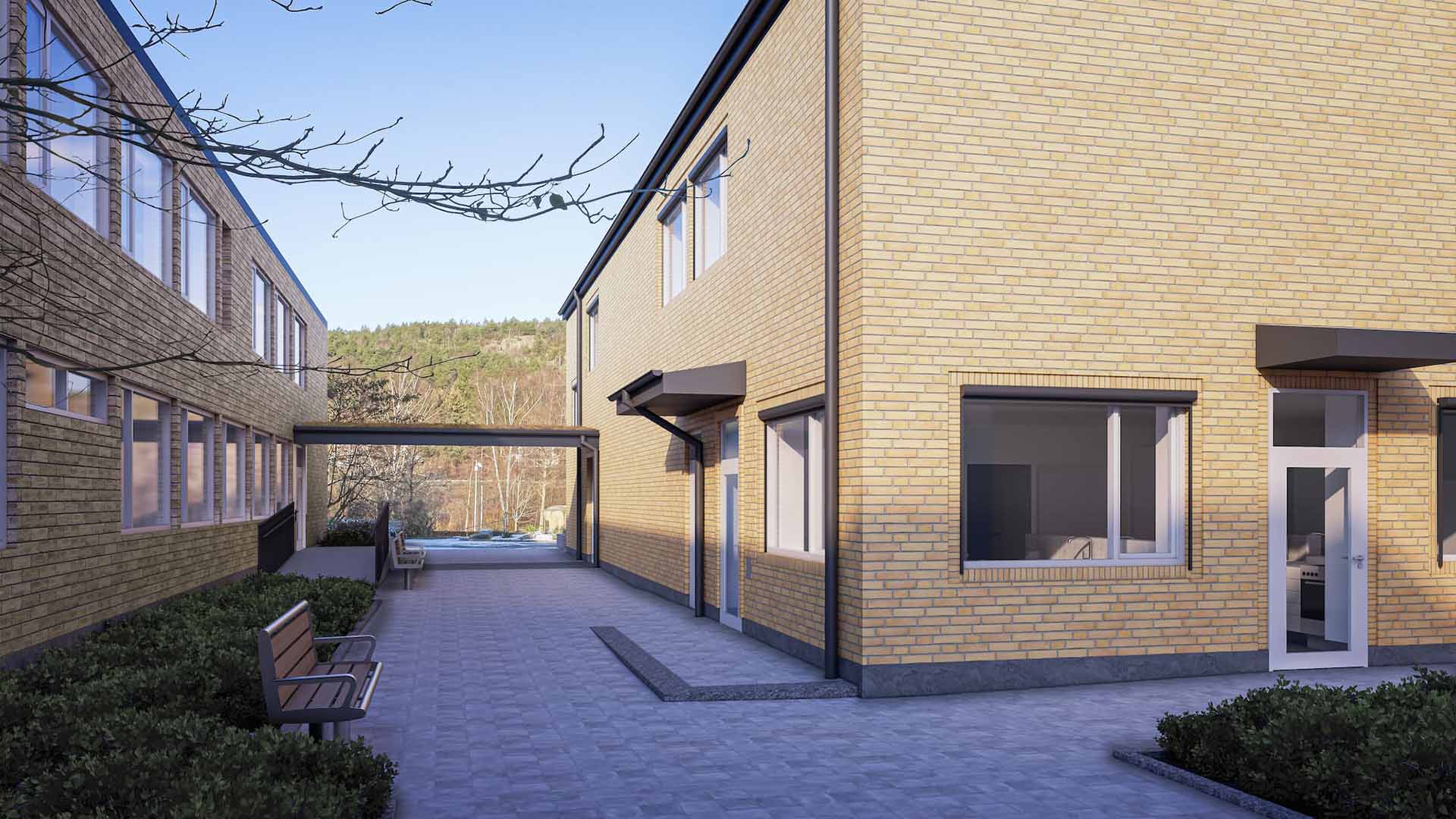 Två byggnader i tegel med skärmtak mellan.